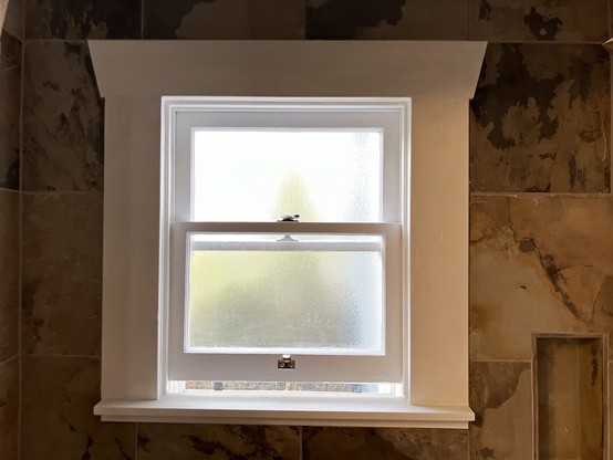 The same window, now painted white with the hardware cleaned and the painter’s tape removed.